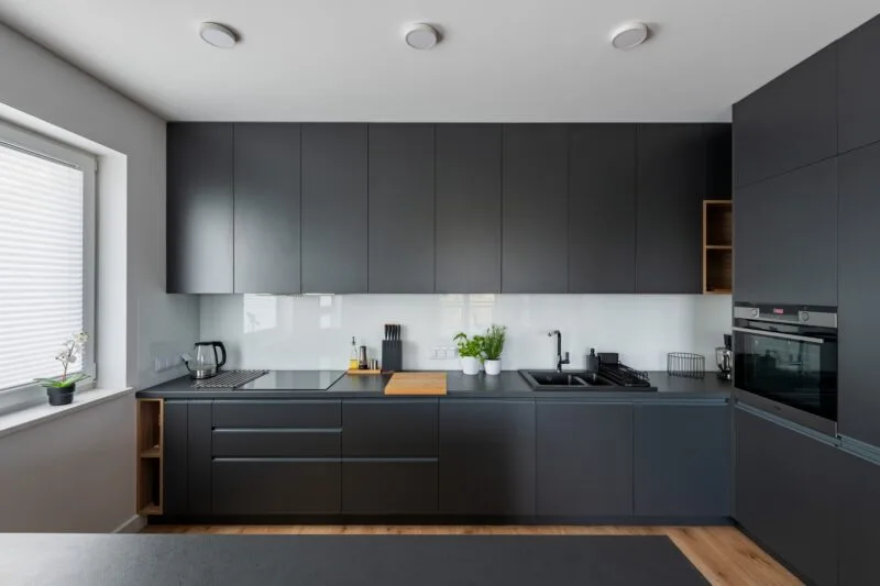 Nowoczesna kuchnia z frontami w kolorze antracytu i drewnianymi akcentami – projekt kuchni Warszawa