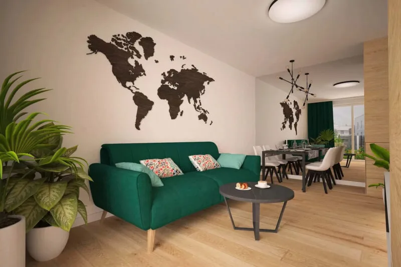 Duży jasny salon. Zielona sofa z czarnym stolikiem. Duży, czarny stół z czterema biały krzesłami. Wielkie lustro na całą boczną ścianę i 2 duże rośliny w białych donicach.