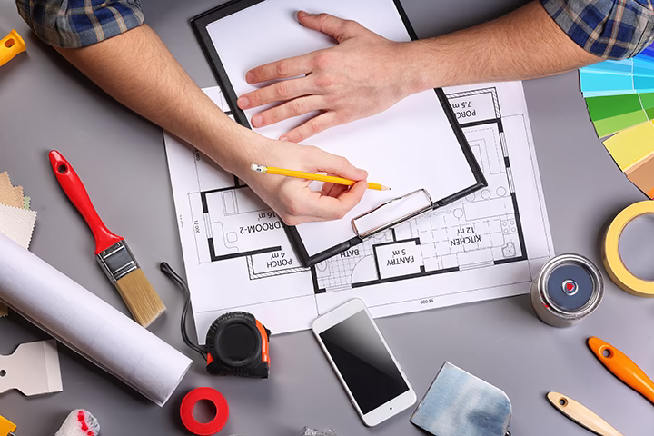 Projektant wnętrz pracujący nad planem mieszkania przy użyciu profesjonalnych narzędzi