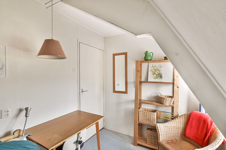 Jasne wnętrze ze stołem, regałem i fotelem w rustykalnym stylu.