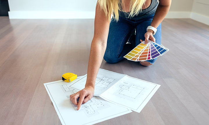 Architekt wnętrz analizuje plany mieszkania i dobiera kolory wykończenia