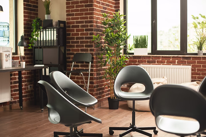 Nowoczesne biuro, sala spotkań, cegła, krzesła, rośliny, funkcjonalne wnętrze.
