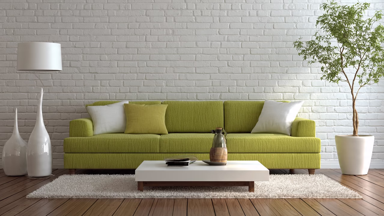 Zielona sofa w nowoczesnym salonie na tle białej cegły.