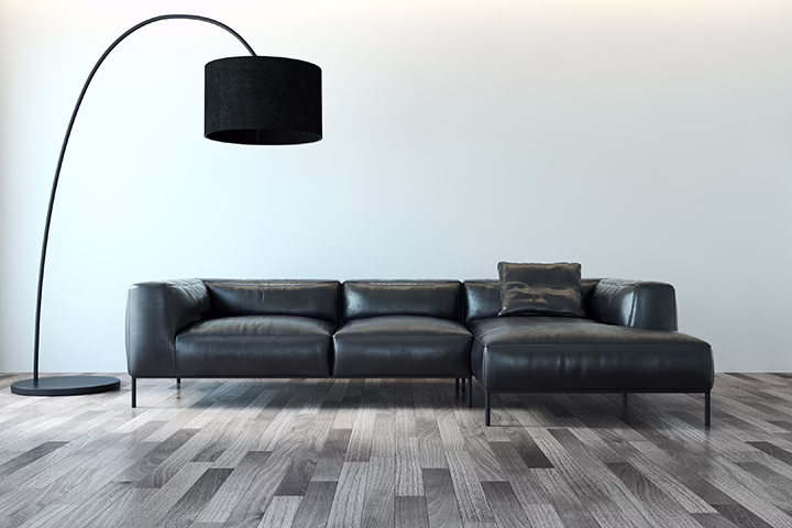 Nowoczesna czarna sofa i designerska lampa łukowa w salonie.