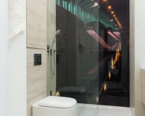 Designerska łazienka z grafiką miejską i minimalistycznym wyposażeniem – funkcjonalne wnętrze Łazienka z prysznicem walk-in i fototapetą z mostem – nowoczesna aranżacja z wiszącą toaletą