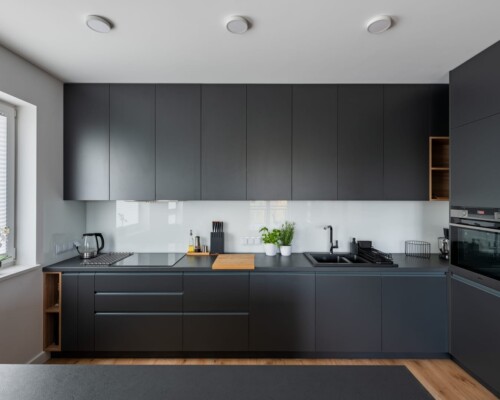 Kuchnia z dominacją antracytu i drewnianymi detalami – elegancja i funkcjonalność Nowoczesna kuchnia z frontami w kolorze antracytu i drewnianymi akcentami – projekt kuchni Warszawa