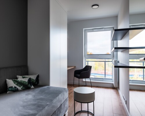 Jasna sypialnia – prostota i komfort Sypialnia z dużym oknem, wyjściem na balkon i nowoczesnym wystrojem