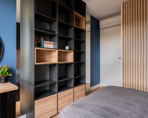 Organizacja w stylu – praktyczna i elegancka garderoba Garderoba z czarno-drewnianą zabudową, otwartymi półkami i miejscem do przechowywania